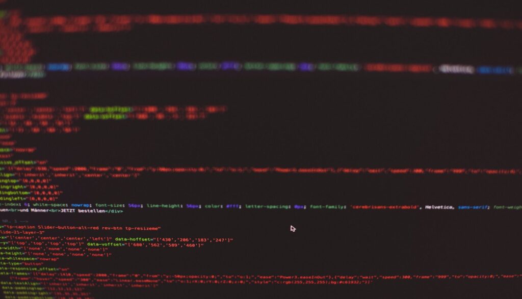 Close-up of colourful HTML and CSS code on a dark computer screen.